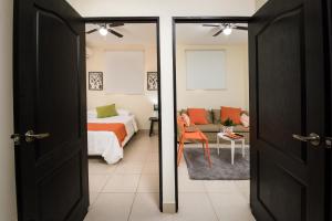 1 dormitorio con 1 cama y 1 habitación con sofá en Verona ApartHotel, en Managua