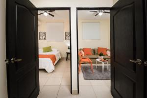 a bedroom with a bed and a room with a couch at Verona ApartHotel in Managua