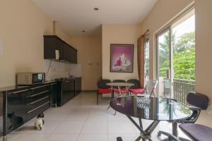 a kitchen and living room with a table and a cat at RedDoorz Syariah Plus @ Wisma Bougenville Karawaci in Tangerang