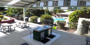 a patio with tables and chairs and a pool at Sundown Villas in Canberra
