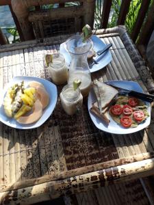 Una mesa con dos platos de comida encima. en Tropical Sunday Bungalow - Surf And Stay, en Selong Belanak