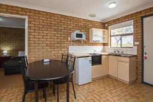 een keuken en eetkamer met een tafel en stoelen bij Cervantes Pinnacles Motel in Cervantes
