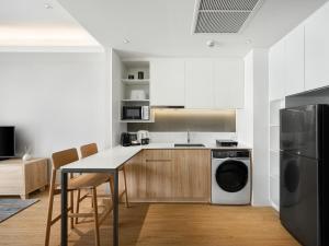 a kitchen with a table and a washer and dryer at Oakwood Suites Bangkok in Bangkok