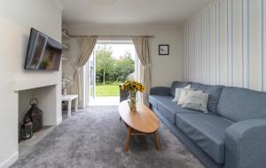 uma sala de estar com um sofá azul e uma mesa em Number Five em Somerton