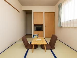 Tabist Business Ryokan Duck Ishinomaki Hebita في إيشينوماكي: غرفة طعام مع طاولة وكراسي