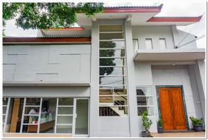 een wit huis met een oranje deur en ramen bij RedDoorz near Jogja City Mall 4 in Yogyakarta