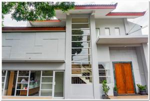 uma casa branca com uma porta laranja e janelas em RedDoorz near Jogja City Mall 4 em Yogyakarta