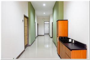 a hallway of a kitchen with green and white walls at RedDoorz near Jogja City Mall 4 in Yogyakarta