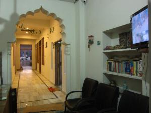 a hallway with a living room with a tv and chairs at Atithi Guest House Pushkar in Pushkar