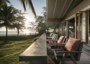 eine Reihe von Chaiselongues auf einer Veranda in der Unterkunft Umadewi Surf & Retreat in Pulukan