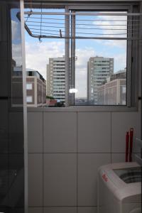 a bathroom with a window with a view of a city at Apartamento Aeroporto/ Uniube in Uberaba