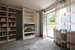 a living room with a tv and a book shelf at Hotel Apollo Garni in Regensburg