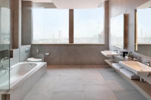 a large bathroom with two sinks and a tub and a toilet at Novotel Jakarta Mangga Dua Square in Jakarta