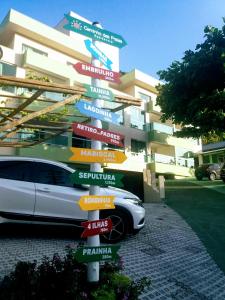 a car parked in front of a building with signs at Residencial Caminho das Praias in Bombinhas