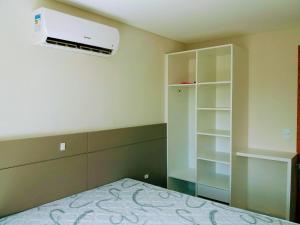 um quarto com uma cama e ar condicionado em Residencial Caminho das Praias em Bombinhas