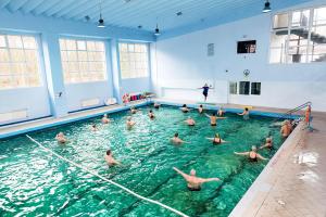 a group of people swimming in a swimming pool at HOLTUR Kołobrzeg - Sanatorium Uzdrowiskowe in Kołobrzeg