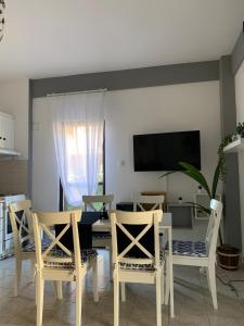 a dining room with a table and chairs and a tv at Lucas Lux Flogita apartment in Flogita