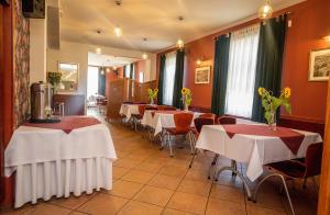 a restaurant with tables and chairs with white tablecloths at Pensjonat Rogatka in Osieczna