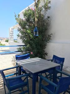 una mesa y sillas con una luz en la parte superior en Naoussa Hotel Paros by Booking Kottas, en Naousa
