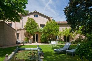 a house with a yard with chairs and a pond at Le Mas du Chanoine in Saint Paul de Vence