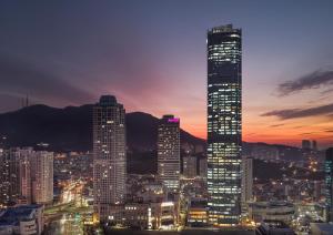 een skyline van de stad met 's nachts hoge gebouwen bij Avani Central Busan in Busan