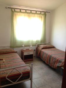 - une chambre avec 2 lits et une fenêtre dans l'établissement Casa nel vigneto con vista mare, à Magomadas