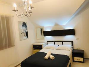 Un dormitorio con una cama blanca y negra y una lámpara de araña en SWEET HOUSES VILLa, en Brasov