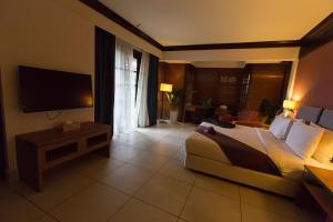 a hotel room with a bed and a television at Sebana Cove Resort in Pengerang