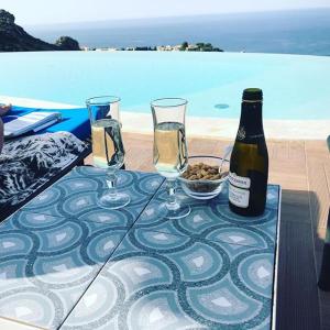 スコペッロにあるHotel Antica Cascina Del Golfoのグラス2杯とワイン1本付きテーブル