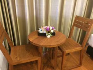 a wooden table topped with a vase filled with flowers at Double DD House at MRT Sutthisarn in Bangkok