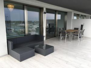 una sala da pranzo con tavolo, sedie e finestre di Laguna Palace Resort Apartment ad Aprilia Marittima