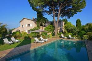 a swimming pool in front of a house at Le Mas du Chanoine in Saint Paul de Vence
