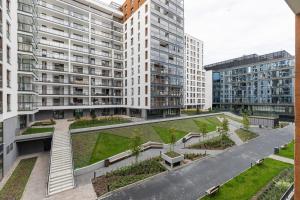 een appartementencomplex met een binnenplaats met planten en gebouwen bij Rent like home - Grzybowska 85 II in Warschau