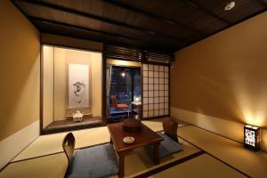 um quarto com uma mesa e cadeiras e uma janela em Matsubaya Ryokan em Quioto