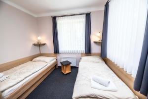 a hotel room with a bed and a desk at Parkhotel Skalní město in Jičín