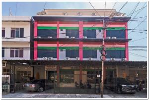 a colorful building with cars parked in front of it at RedDoorz near JIEXPO Kemayoran 2 in Jakarta