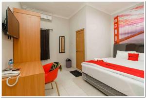 a bedroom with a bed and a desk with a computer at RedDoorz near JIEXPO Kemayoran 2 in Jakarta