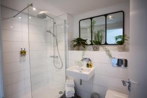 a white bathroom with a shower and a sink at Owen House Farm in Knutsford