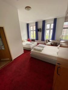 2 Betten in einem Zimmer mit einem roten Teppich in der Unterkunft Märkischer Hof Hotel in Berlin