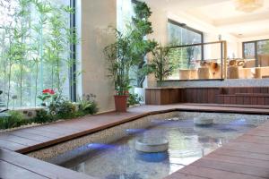 a pool in the middle of a house with plants at Gamalan FL Spring Hotel in Jiaoxi