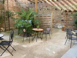 a patio with a table and chairs and a brick wall at Toscanahaus in Bad Sobernheim