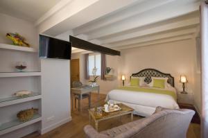 a hotel room with a bed and a tv at Le Mas du Chanoine in Saint Paul de Vence