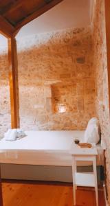 a bedroom with a white bed and a small table at Porta Medina Boutique Hotel in Heraklio