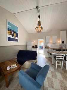 a living room with a blue chair and a table at L'annexe de Gaston in Le Port-des-Barques