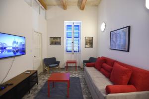 - un salon avec un canapé rouge et une télévision dans l'établissement Grand Harbour Apartments, à Il-Furjana