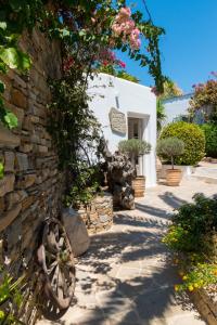 una pared de piedra con una rueda delante de un edificio en Kavos Hotel Naxos, en Agios Prokopios