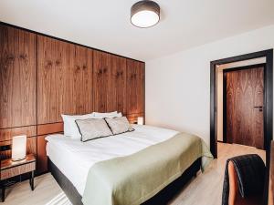 um quarto com uma cama grande e paredes de madeira em Apartamenty Sowa Bydgoszcz em Bydgoszcz