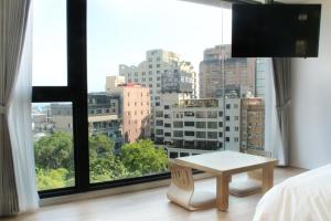 a bedroom with a view of a city from a window at Gamalan FL Spring Hotel in Jiaoxi