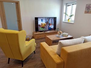 a living room with a couch and a tv at Shiny Apartmán in Spišská Nová Ves