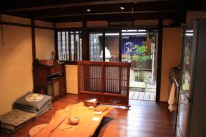 a living room with a table and a room with a window at Onoan in Hida